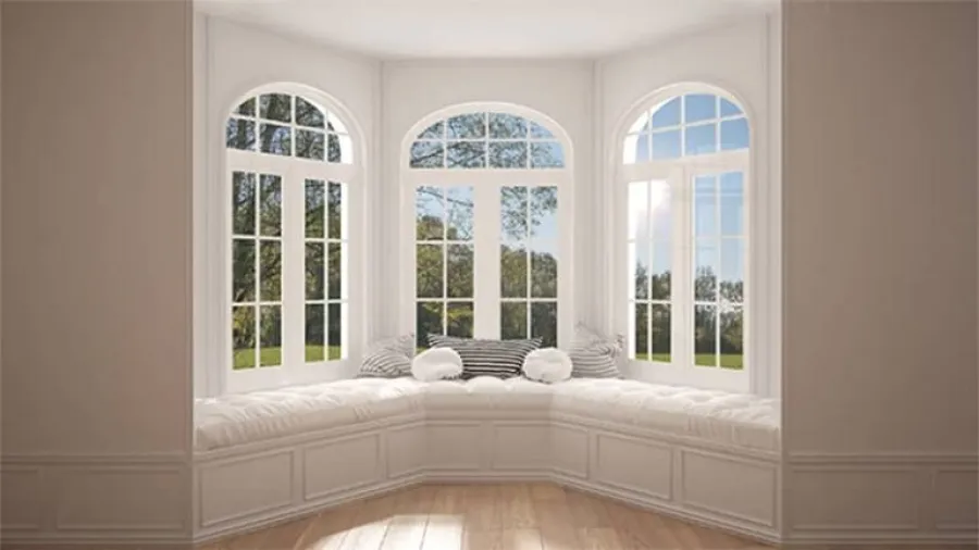 a bed in a room with large windows