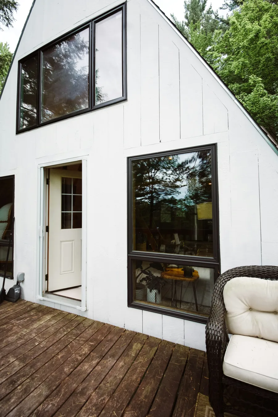 a white house with a deck and a chair and a table