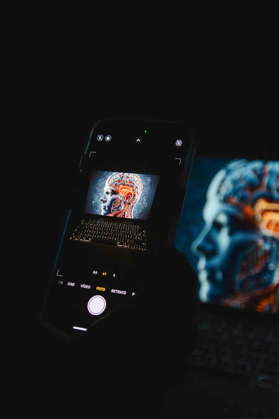 Smartphone camera capturing a digital image of a human head with a glowing brain and circuit patterns.