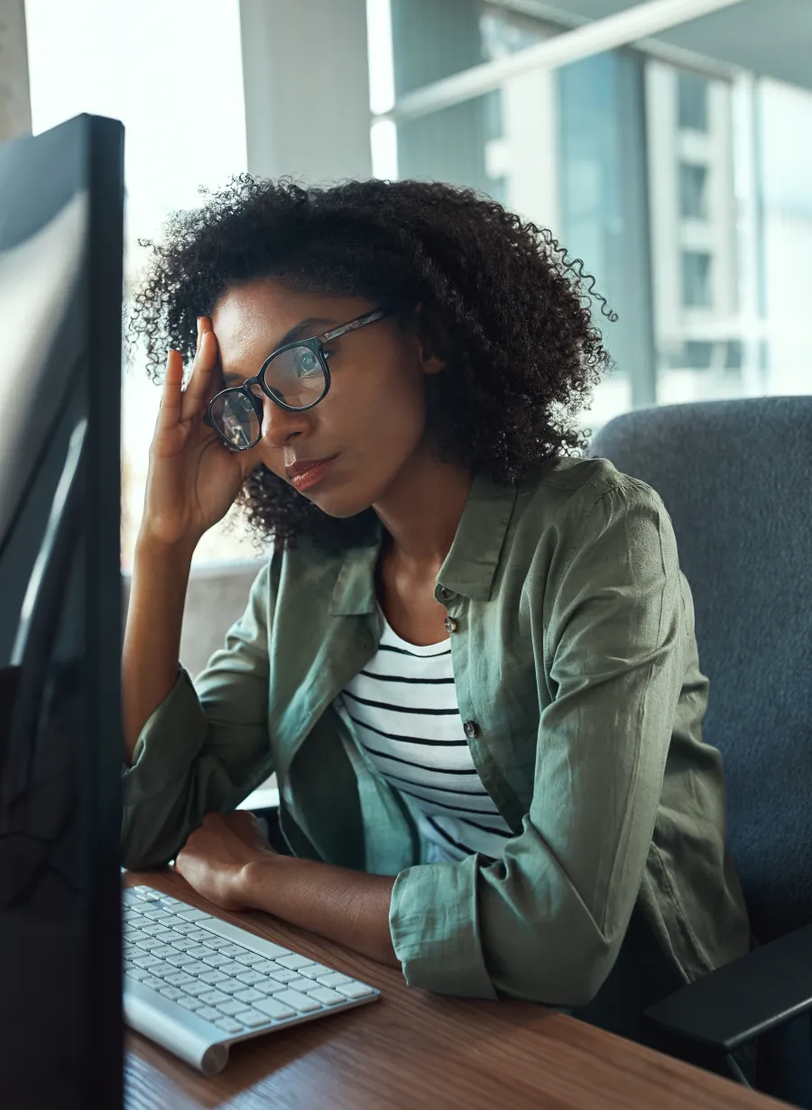 a person sitting at a desk with a laptop and a phone