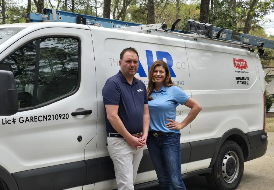 a man and a woman standing in front of a white van