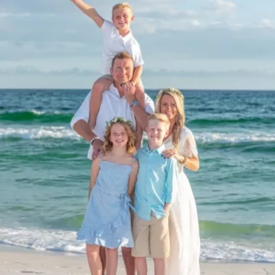 a family posing on a beach