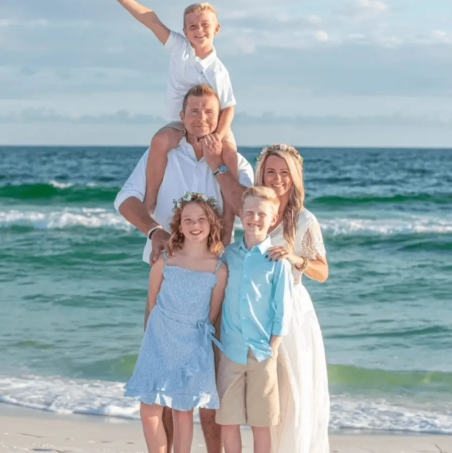 a family posing on a beach