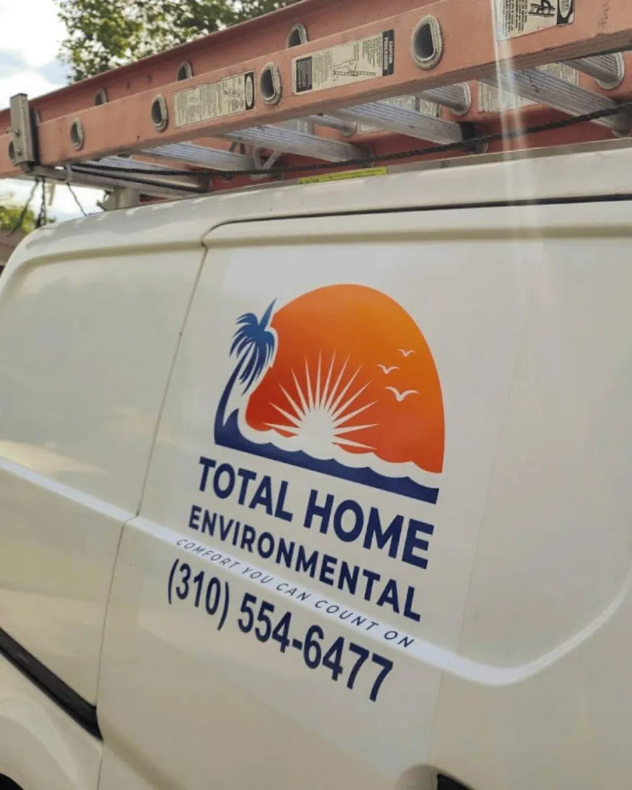 Total Home Environmental logo with sunrise, palm tree, and contact number on white service van with ladder.