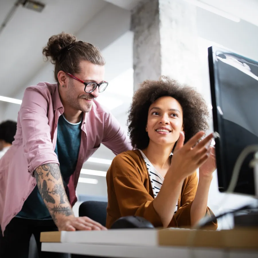 a man and a woman looking at a computer screen