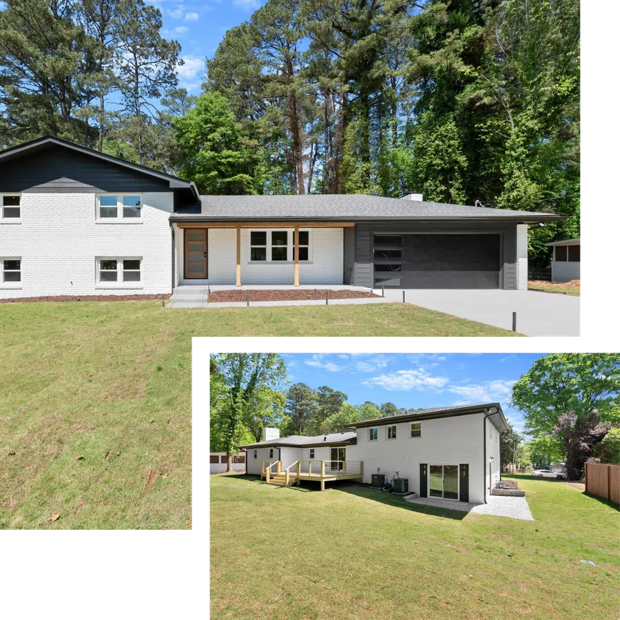 Modern two-story white brick house with black roof and garage surrounded by a green lawn and tall trees.