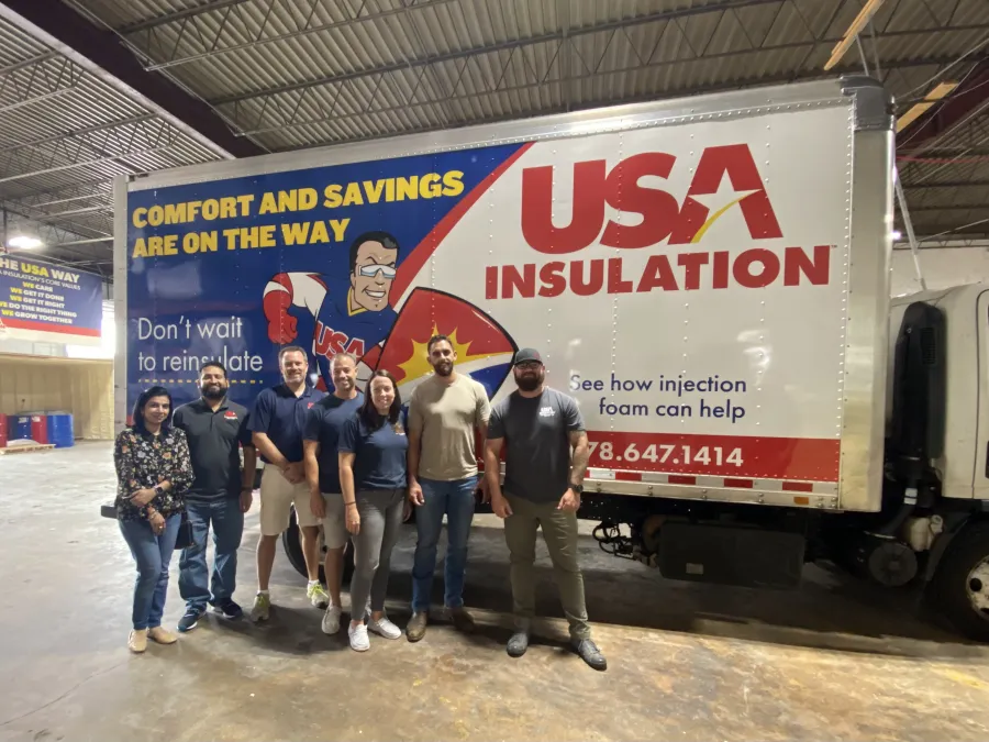 a group of people standing in front of a large truck