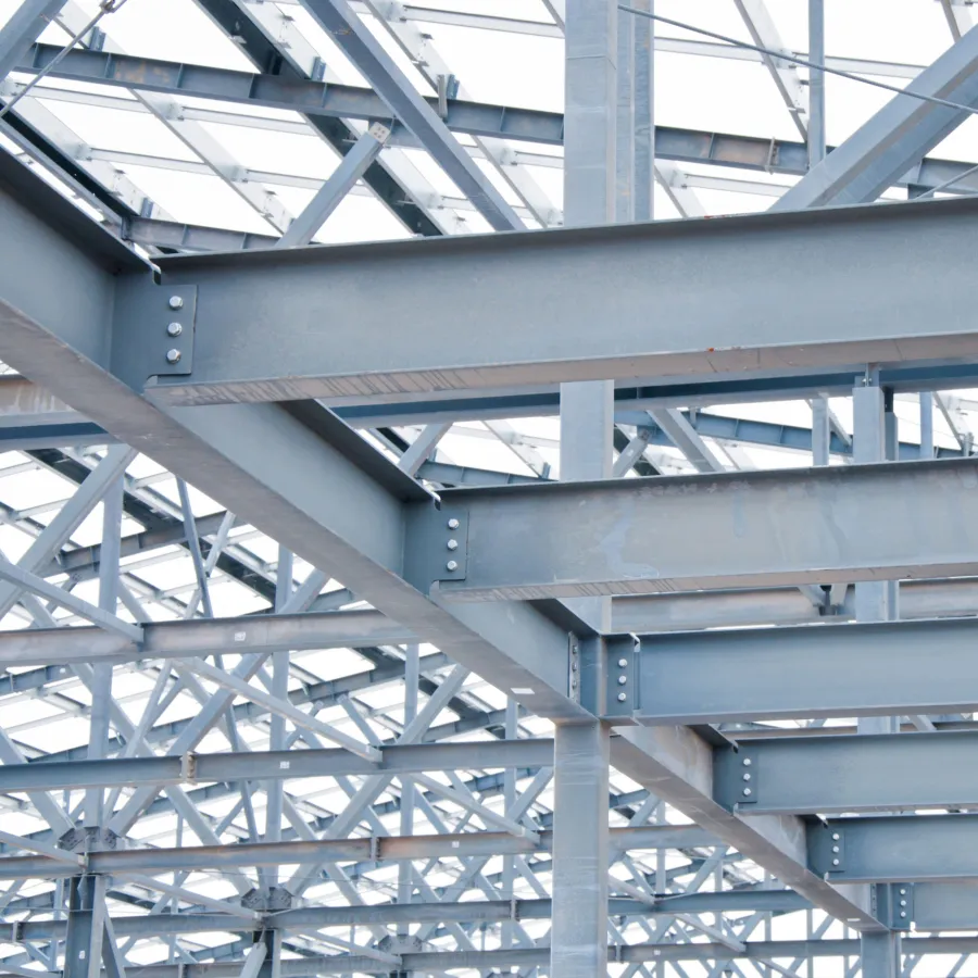 Close-up of intersecting steel beams and bolts in a metal building structure under construction.