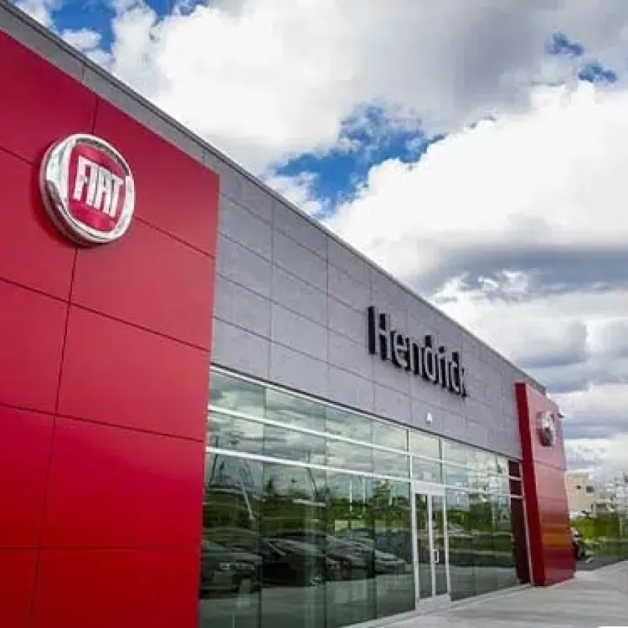 Fiat dealership building with red and gray exterior under a partly cloudy sky.