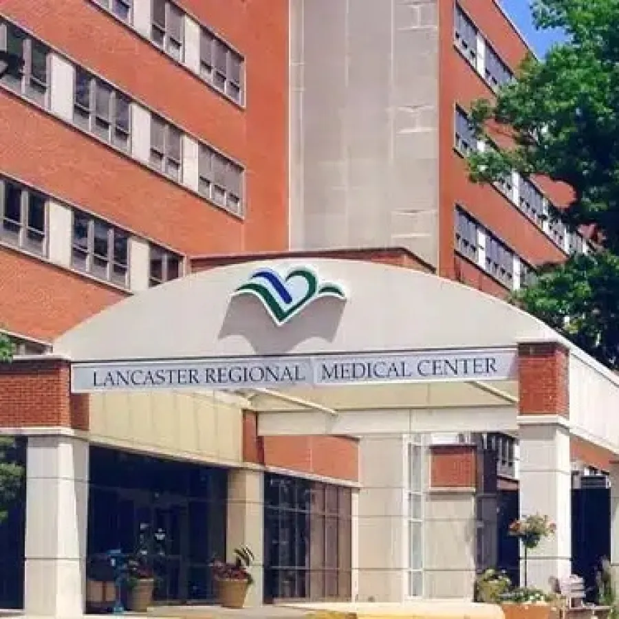 Entrance of Lancaster Regional Medical Center with signage, surrounded by trees and brick buildings on a sunny day