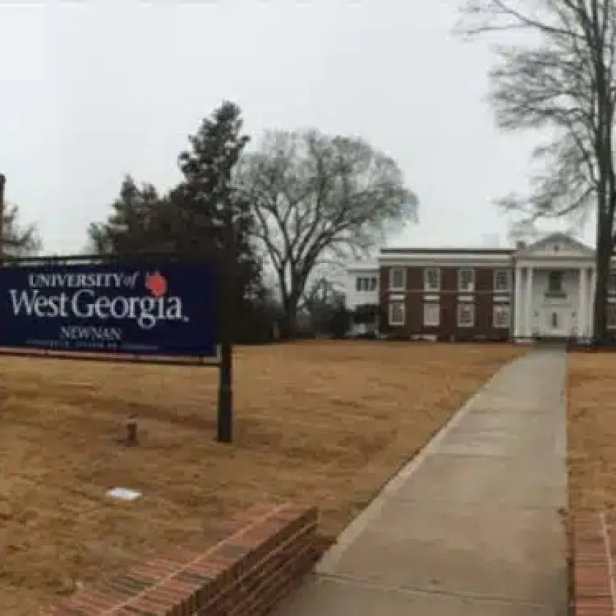 Entrance to University of West Georgia Newman Hall with sign and pathway on a cloudy day.