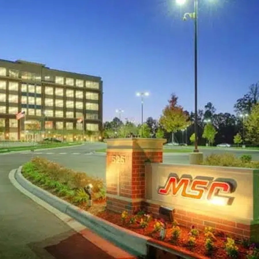 MSC office building illuminated at dusk with landscaped entrance and sign in foreground.