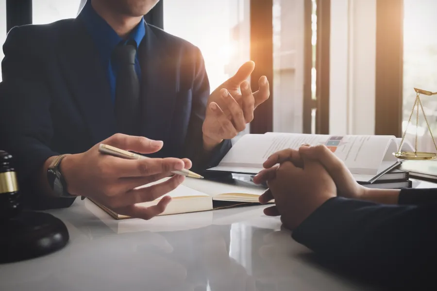 a person in a suit and tie holding a pen and a paper