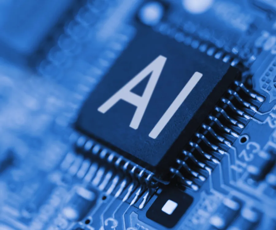 Close-up of a computer chip labeled AI on a blue printed circuit board symbolizing artificial intelligence technology.
