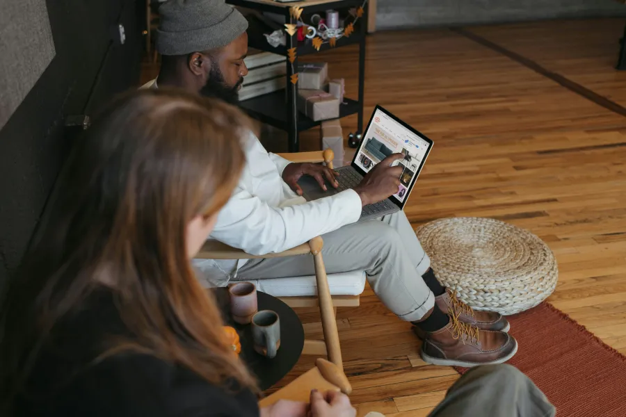 a man and woman sitting on a chair with a laptop