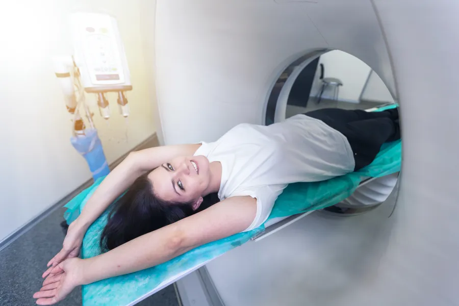 Woman undergoing a medical imaging procedure in a modern clinic setting.