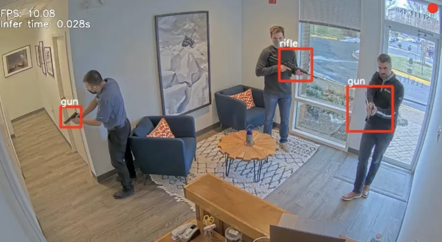 Three men holding firearms inside a modern office lobby with seating and large windows.