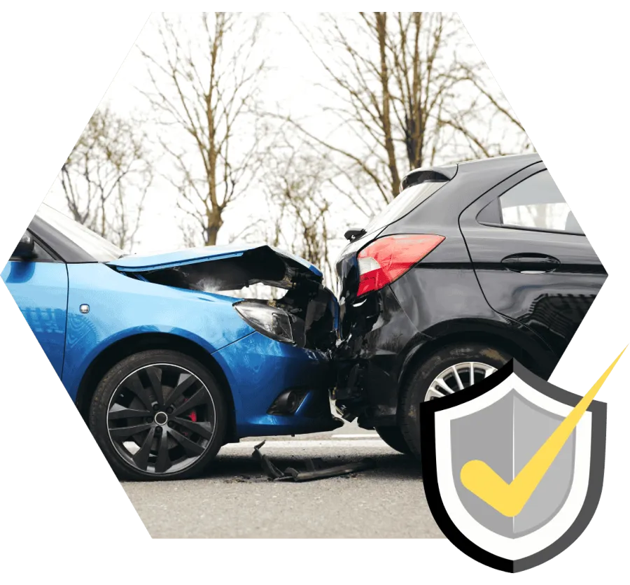 Blue car rear-ends black car on road with visible front and rear damage under bare trees in daylight.