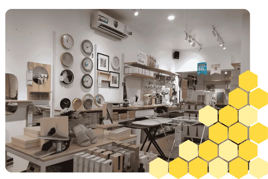 Homeware store interior with clocks, mirrors, slippers, and shelves of household items under bright lighting.