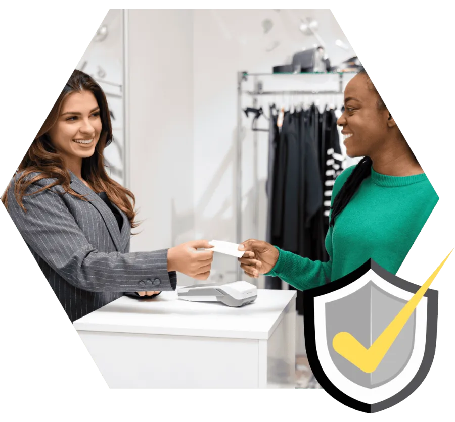 Customer smiling while handing a payment card to a cashier at a modern retail store counter.