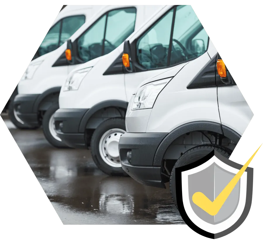 Lineup of white commercial vans parked on wet pavement, showcasing clean and uniform fleet vehicles.